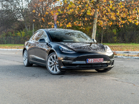 Cluj-Napoca, Cluj-Roumanie-18.11.2024-Isolé pas de gens Tesla modèle 3 Long Range Dual Motor voiture noire, isolée dans un parking vide, gros plan photos, fichiers haute résolution.